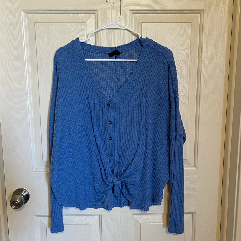 Blue v-neck sweater, button down, tie at the bottom